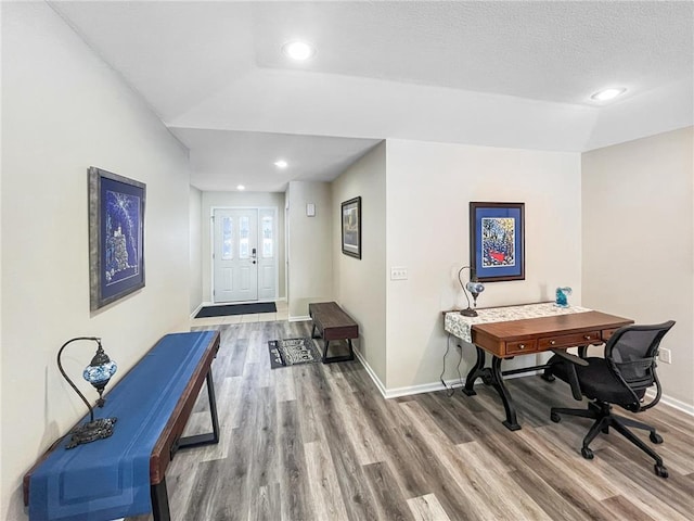 office featuring lofted ceiling, hardwood / wood-style floors, and a textured ceiling