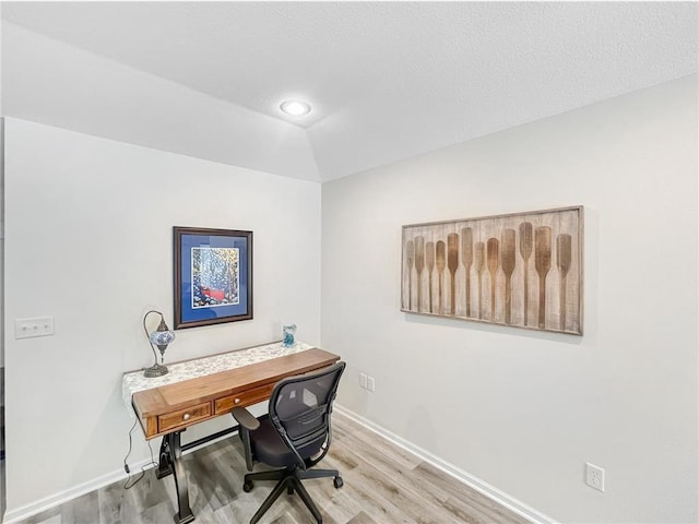 home office with vaulted ceiling and light hardwood / wood-style flooring