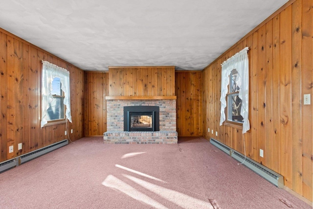 unfurnished living room with carpet, a baseboard heating unit, wood walls, and a fireplace