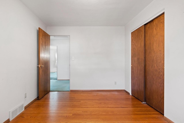 unfurnished bedroom featuring light wood-type flooring and a closet