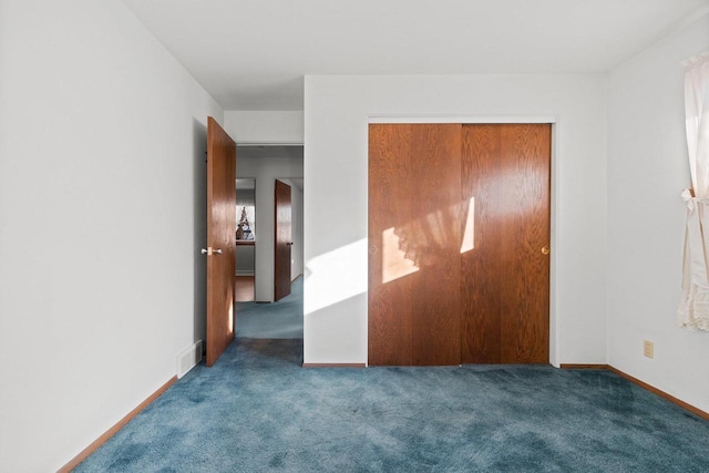 unfurnished bedroom featuring a closet and dark colored carpet