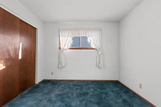 unfurnished bedroom with a closet and dark colored carpet