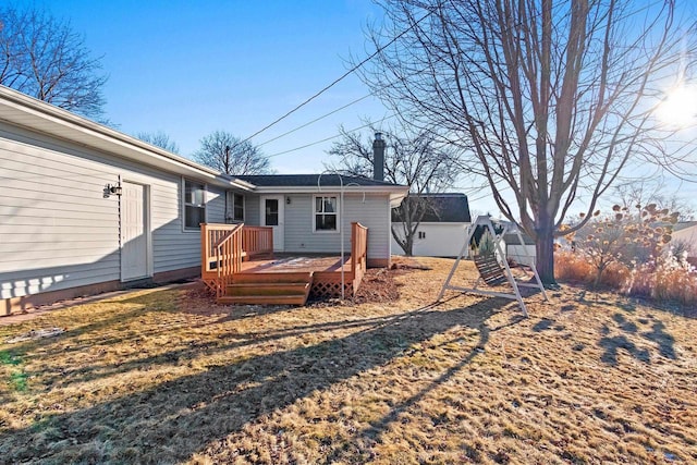 back of house with a deck and a lawn