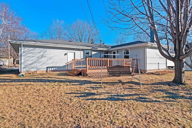 back of house featuring a wooden deck and a yard