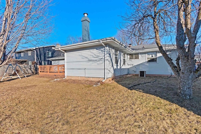 rear view of property with a wooden deck and a yard