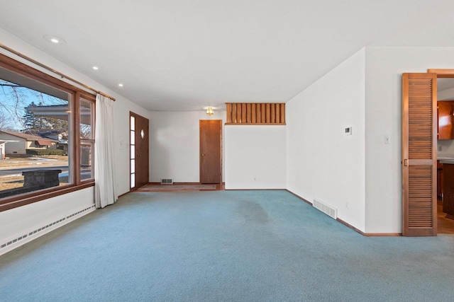 carpeted spare room with a baseboard radiator