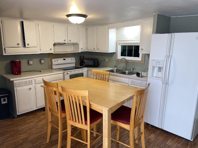 kitchen featuring white cabinetry, sink, white appliances, and dark wood-type flooring