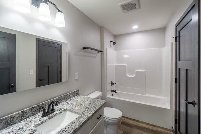 full bathroom with shower / bathing tub combination, hardwood / wood-style floors, toilet, and vanity