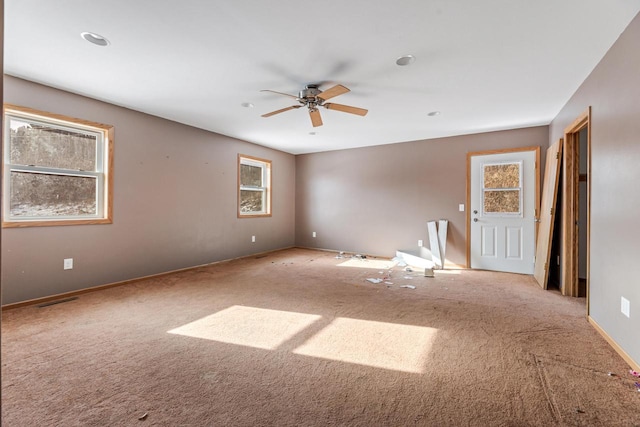 empty room featuring ceiling fan and light carpet