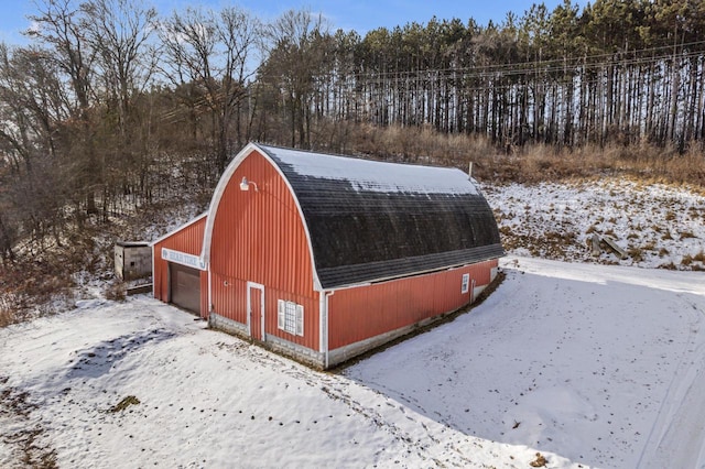 snow covered structure with a garage