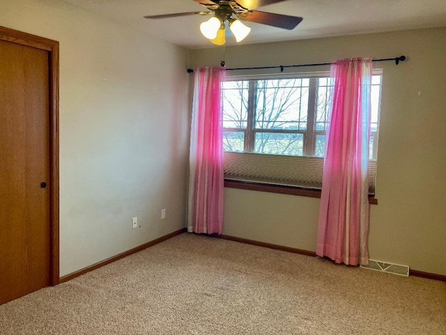 carpeted spare room featuring ceiling fan