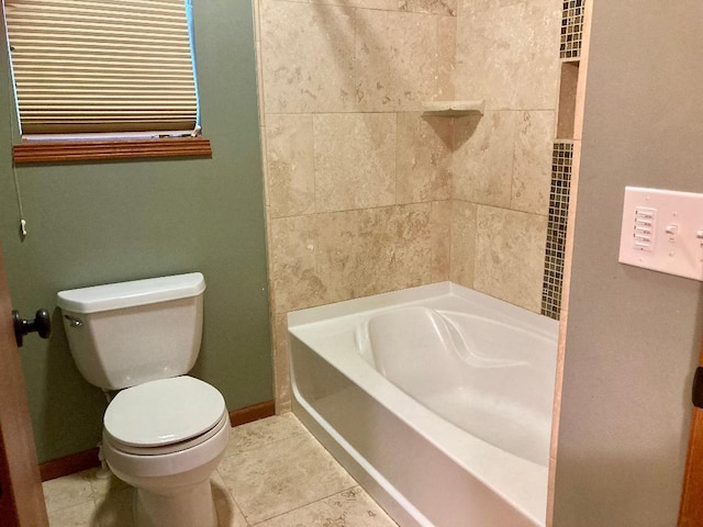 bathroom featuring tile patterned floors, toilet, and a bathing tub