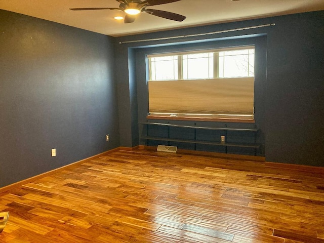 spare room featuring wood-type flooring and ceiling fan