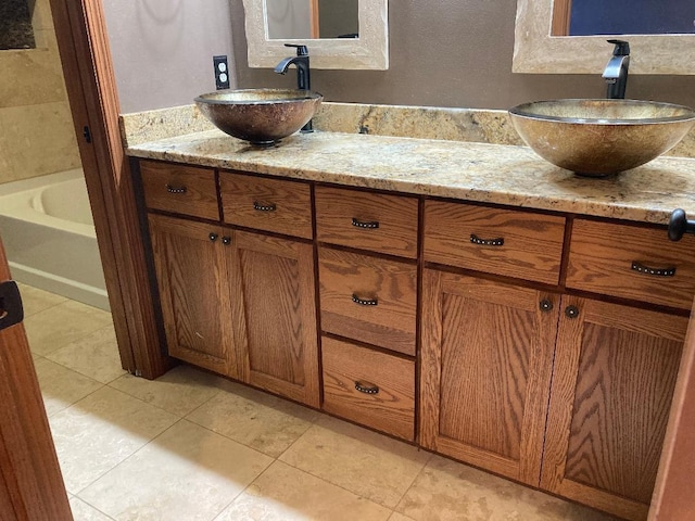 bathroom featuring vanity, a bath, and tile patterned floors