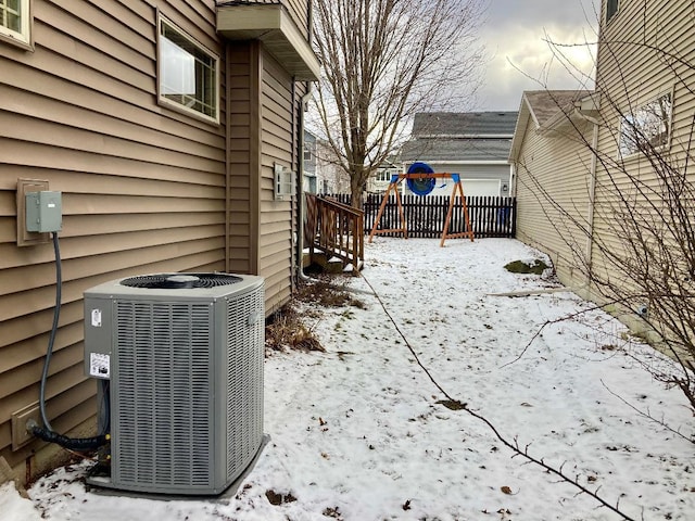 snow covered patio with central air condition unit