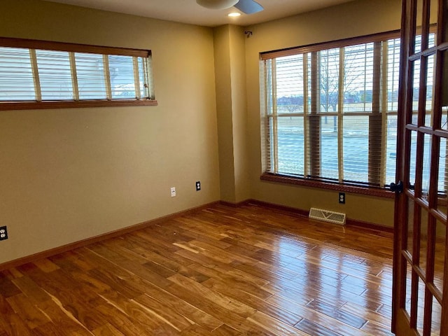 empty room with ceiling fan and hardwood / wood-style floors