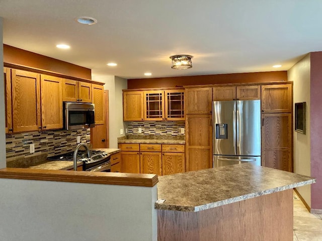 kitchen with sink, tasteful backsplash, light tile patterned floors, appliances with stainless steel finishes, and kitchen peninsula