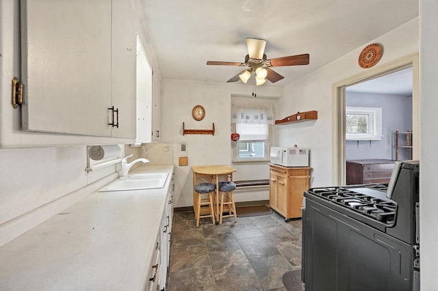 kitchen featuring sink, white cabinetry, and black gas range