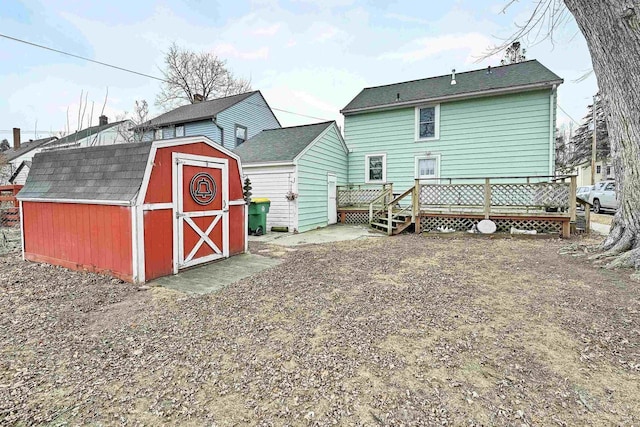 rear view of house with a shed and a wooden deck