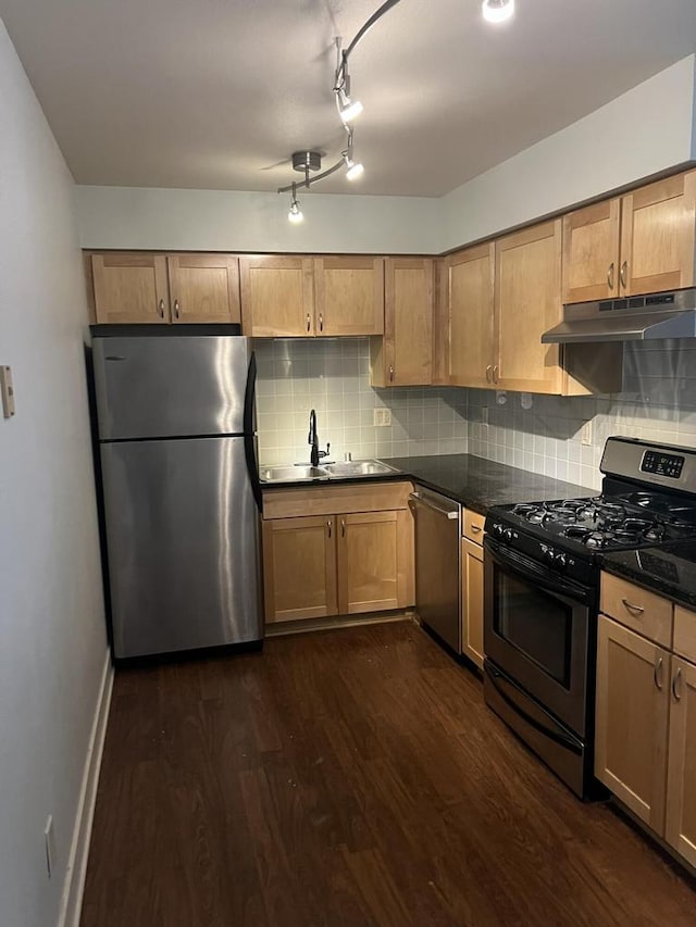 kitchen featuring sink, backsplash, appliances with stainless steel finishes, and dark hardwood / wood-style flooring