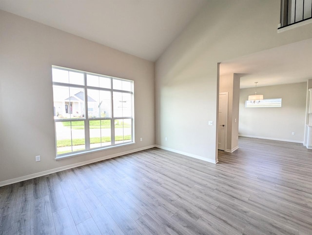 6839 Belle Fontaine Blvd, Middleton, WI 53562 - unfurnished room with wood finished floors, healthy amount of natural light, baseboards, and vaulted ceiling