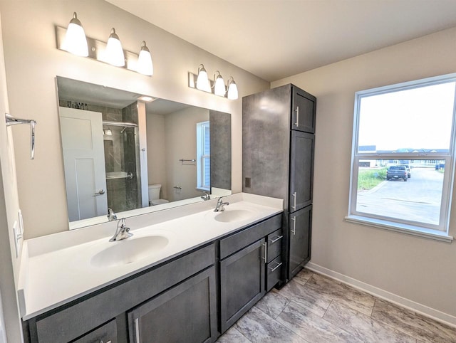 6839 Belle Fontaine Blvd, Middleton, WI 53562 - bathroom featuring toilet, baseboards, double vanity, and a stall shower