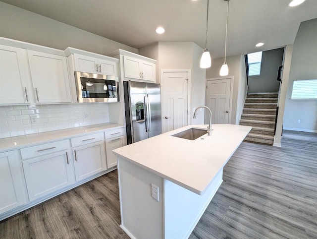 6839 Belle Fontaine Blvd, Middleton, WI 53562 - kitchen featuring appliances with stainless steel finishes, a sink, wood finished floors, white cabinets, and backsplash
