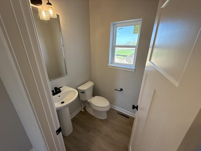 N118W1479 Mistletoe Rd, Germantown, WI 53022 - half bath featuring wood finished floors, toilet, and baseboards