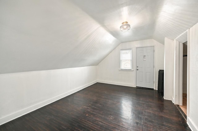 additional living space with dark wood-type flooring and vaulted ceiling