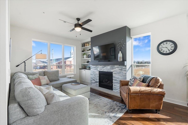 living room featuring a fireplace, dark wood-type flooring, built in features, and ceiling fan