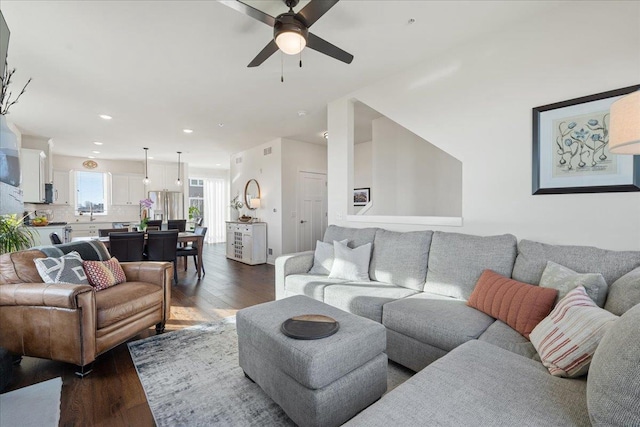 living room with ceiling fan and dark hardwood / wood-style flooring