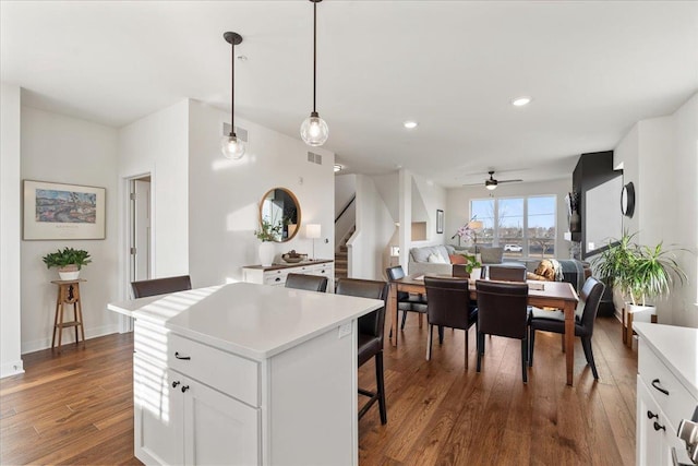 kitchen with a center island, pendant lighting, white cabinets, and dark hardwood / wood-style flooring