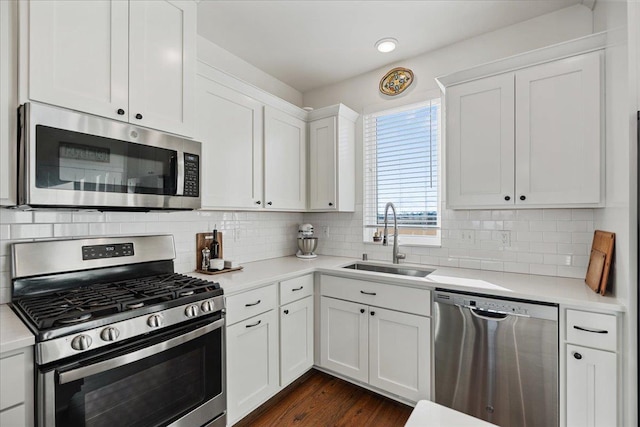 kitchen with sink, tasteful backsplash, appliances with stainless steel finishes, dark hardwood / wood-style flooring, and white cabinets