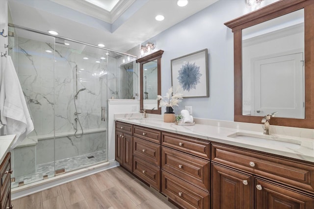 bathroom with a shower with shower door, crown molding, vanity, a raised ceiling, and hardwood / wood-style flooring