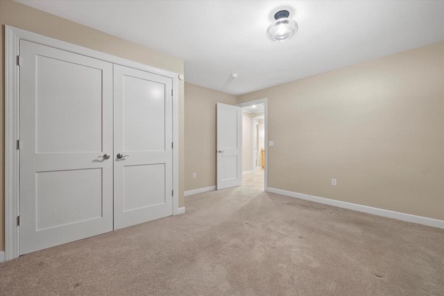 unfurnished bedroom featuring light colored carpet and a closet