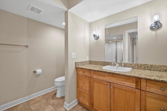 bathroom featuring tile patterned flooring, vanity, a shower with door, and toilet