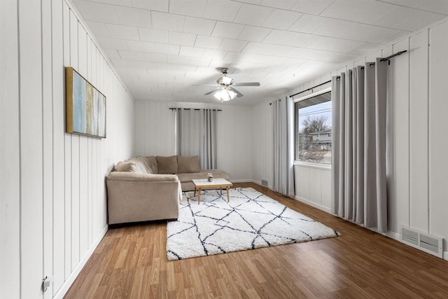 living room with ceiling fan and light hardwood / wood-style flooring