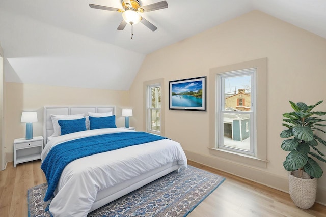 bedroom with ceiling fan, light hardwood / wood-style floors, and lofted ceiling