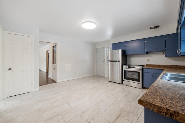 kitchen featuring sink, blue cabinetry, and appliances with stainless steel finishes