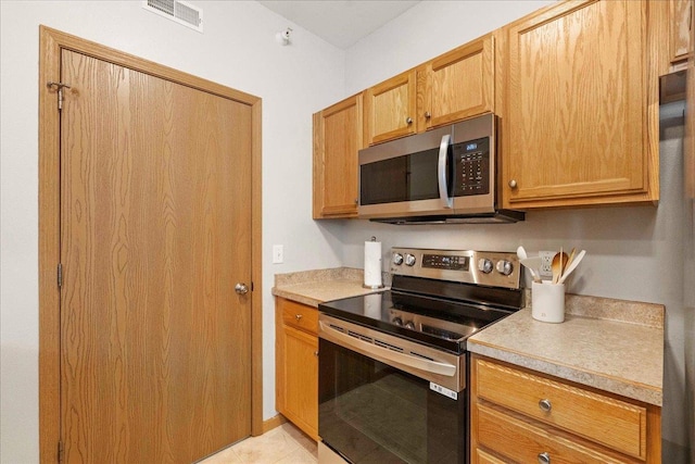 kitchen featuring stainless steel appliances and light tile patterned floors