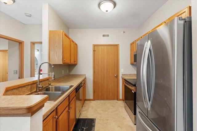 kitchen with sink, appliances with stainless steel finishes, and kitchen peninsula