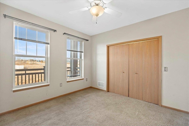 unfurnished bedroom with a closet, ceiling fan, and light colored carpet