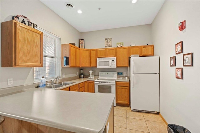 kitchen with sink, white appliances, kitchen peninsula, and light tile patterned floors