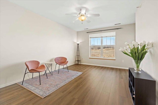 sitting room featuring ceiling fan and dark hardwood / wood-style floors