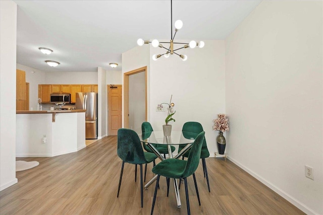 dining area with a chandelier and light hardwood / wood-style flooring