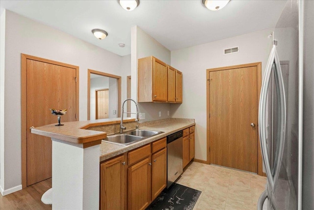 kitchen featuring kitchen peninsula, sink, and appliances with stainless steel finishes