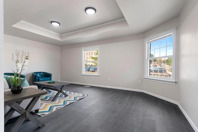 sitting room with a wealth of natural light, crown molding, dark wood-type flooring, and a tray ceiling