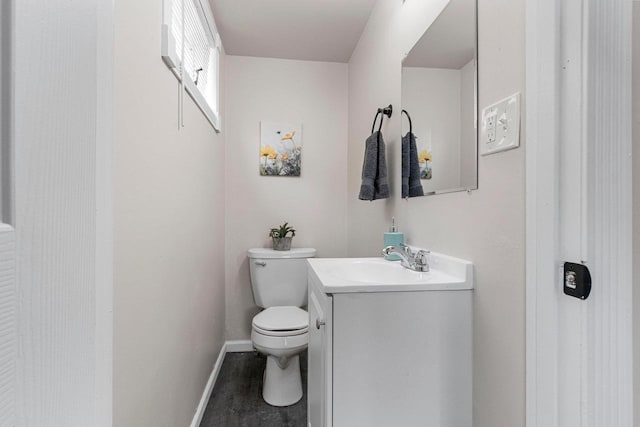 bathroom with wood-type flooring, toilet, and vanity