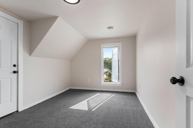 bonus room featuring vaulted ceiling and dark colored carpet