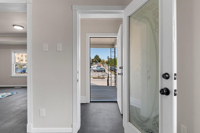 doorway with ornamental molding and plenty of natural light